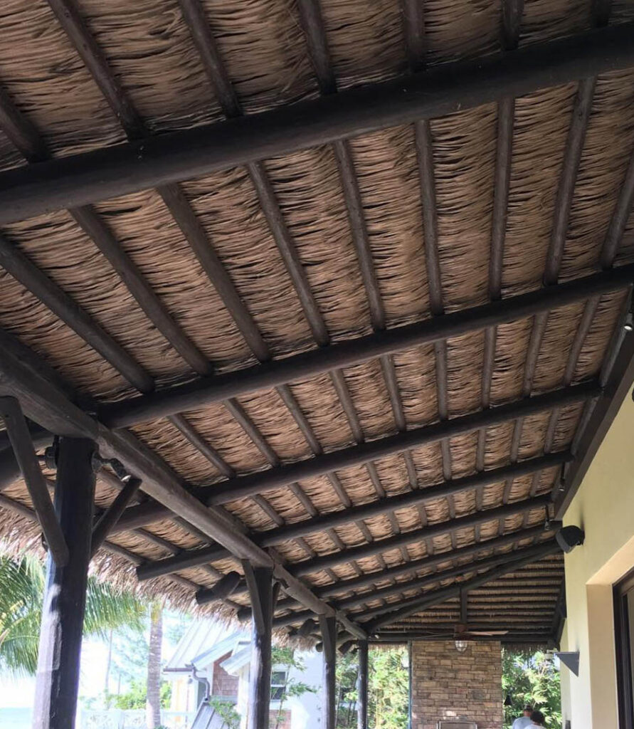 Interior de techo tropical con listón de madera y tejas de palma sintética NIPA en ambiente comercial